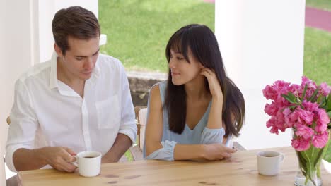 feliz joven pareja mixta sentada en la mesa