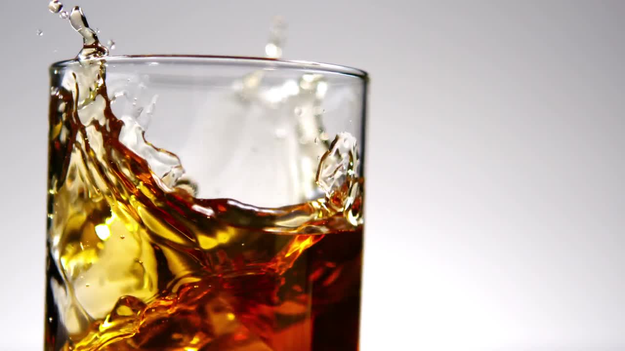 hielo cayendo en un vaso de whisky y hielo