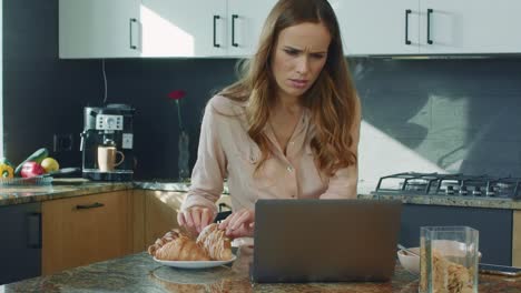 business woman watching video in big kitchen. woman getting shocked news