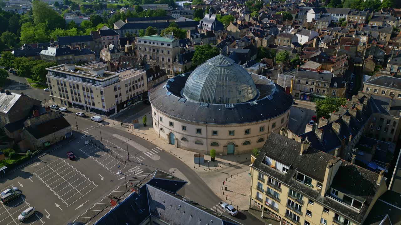 Aerial view of a city with a prominent circular building and glass dome