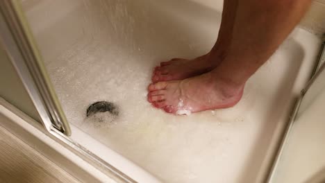 person washing feet in a shower