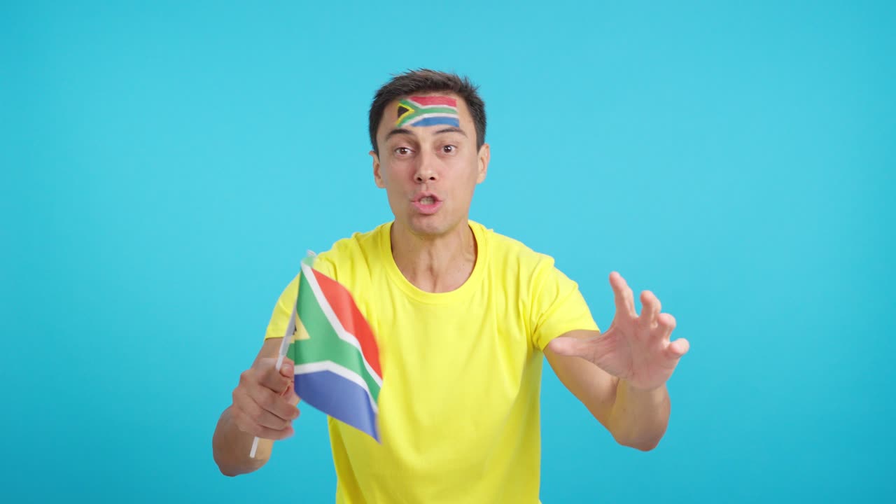 Man cheering for South Africa screaming and waving a national flag