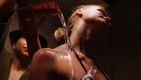 woman getting water poured on her back