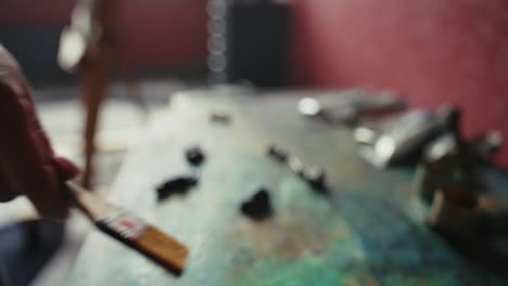 artist's workspace with paint and brush