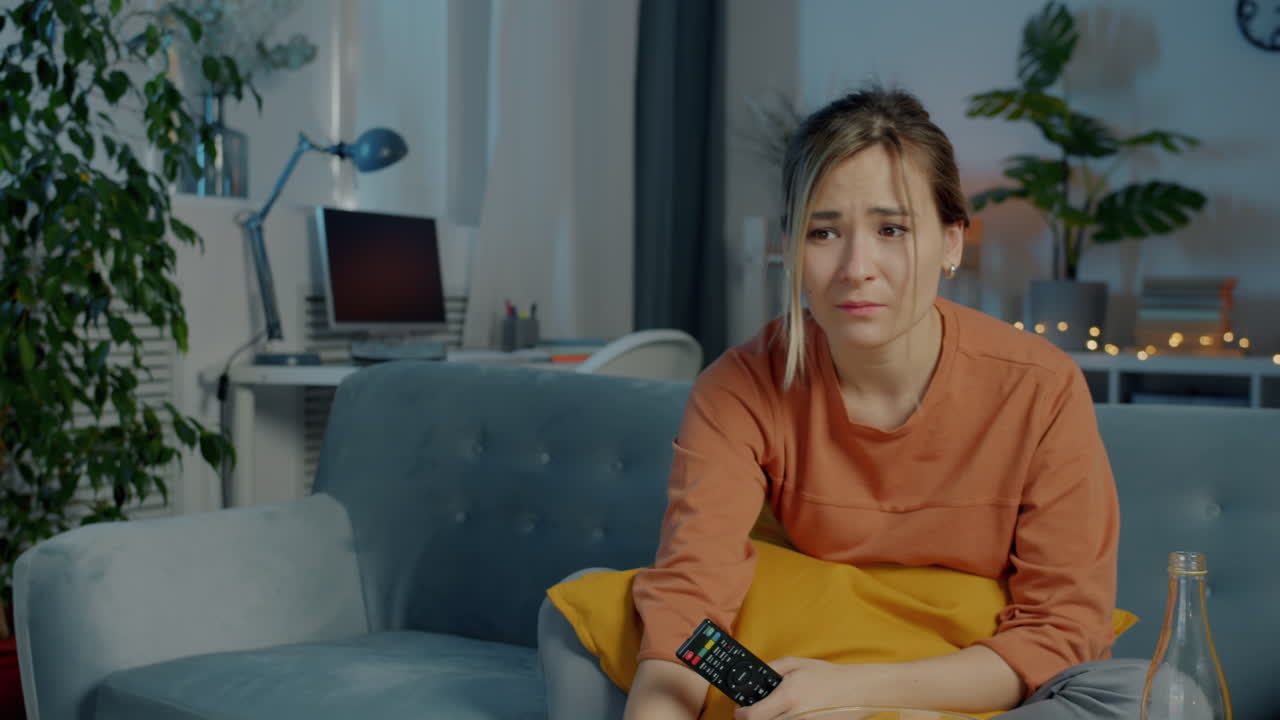 Kvinde ser tv og er ked af det