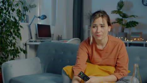woman watching tv and feeling sad