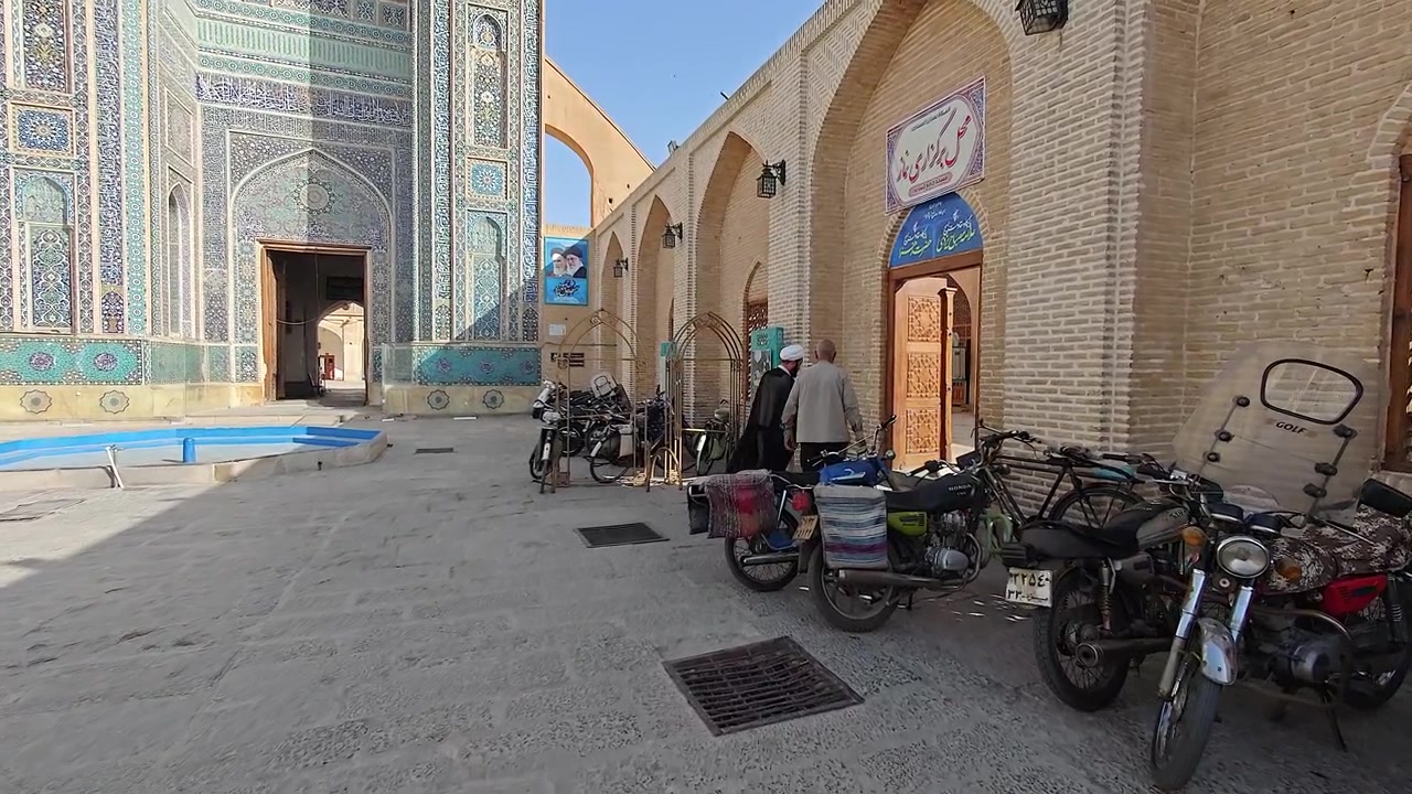 Persone che arrivano in un cortile di moschea tradizionale in Iran