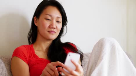 Mujer-Feliz-Usando-Teléfono-Móvil-En-La-Sala-De-Estar