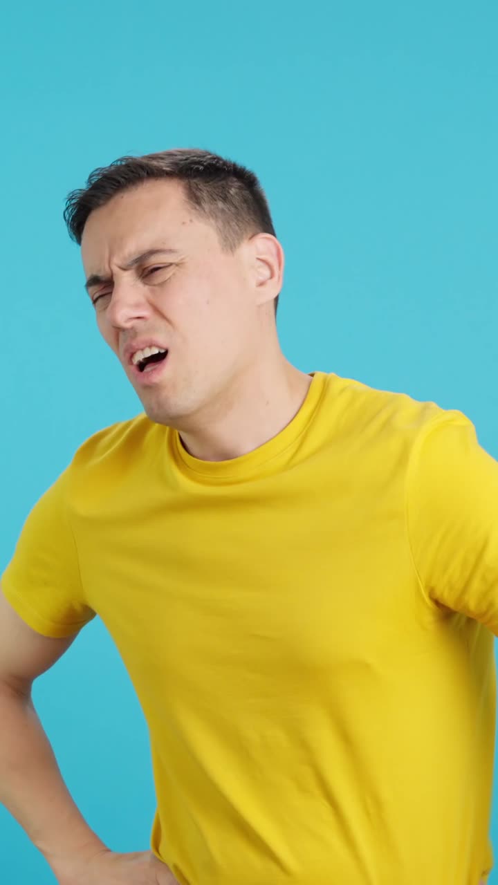 Man in yellow shirt expressing frustration with hand gestures