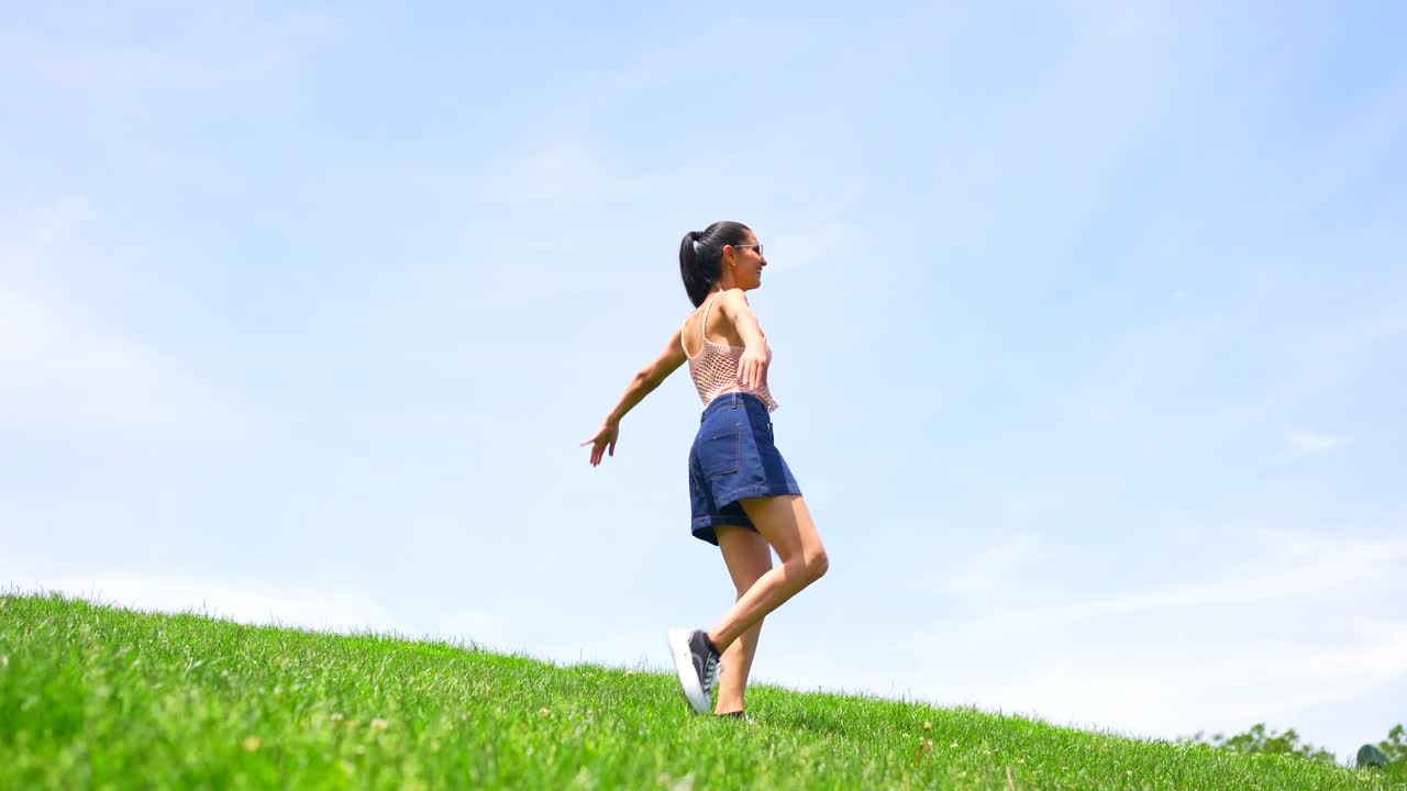 Woman enjoying summer on a grassy hill