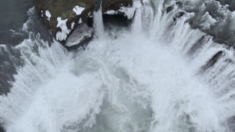 Scenic-waterfall-streaming-from-rocky-cliff-on-winter-day