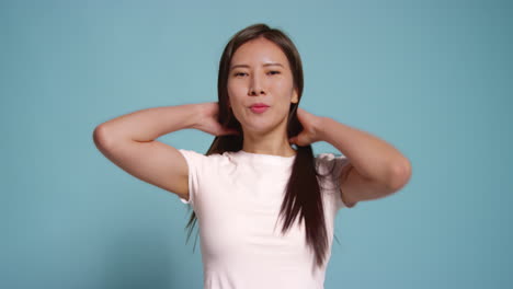 Young-Woman-In-Front-Of-Blue-Studio-Background-Posing-For-Photo-Booth-Style-Portraits