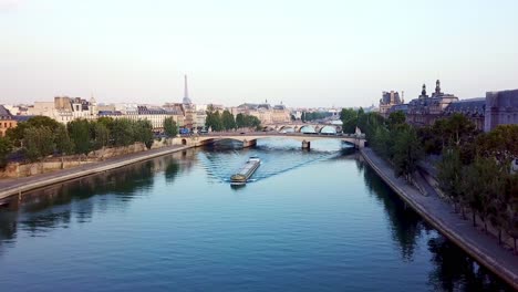 drone flying over freight ship floating on calm seine river in moring