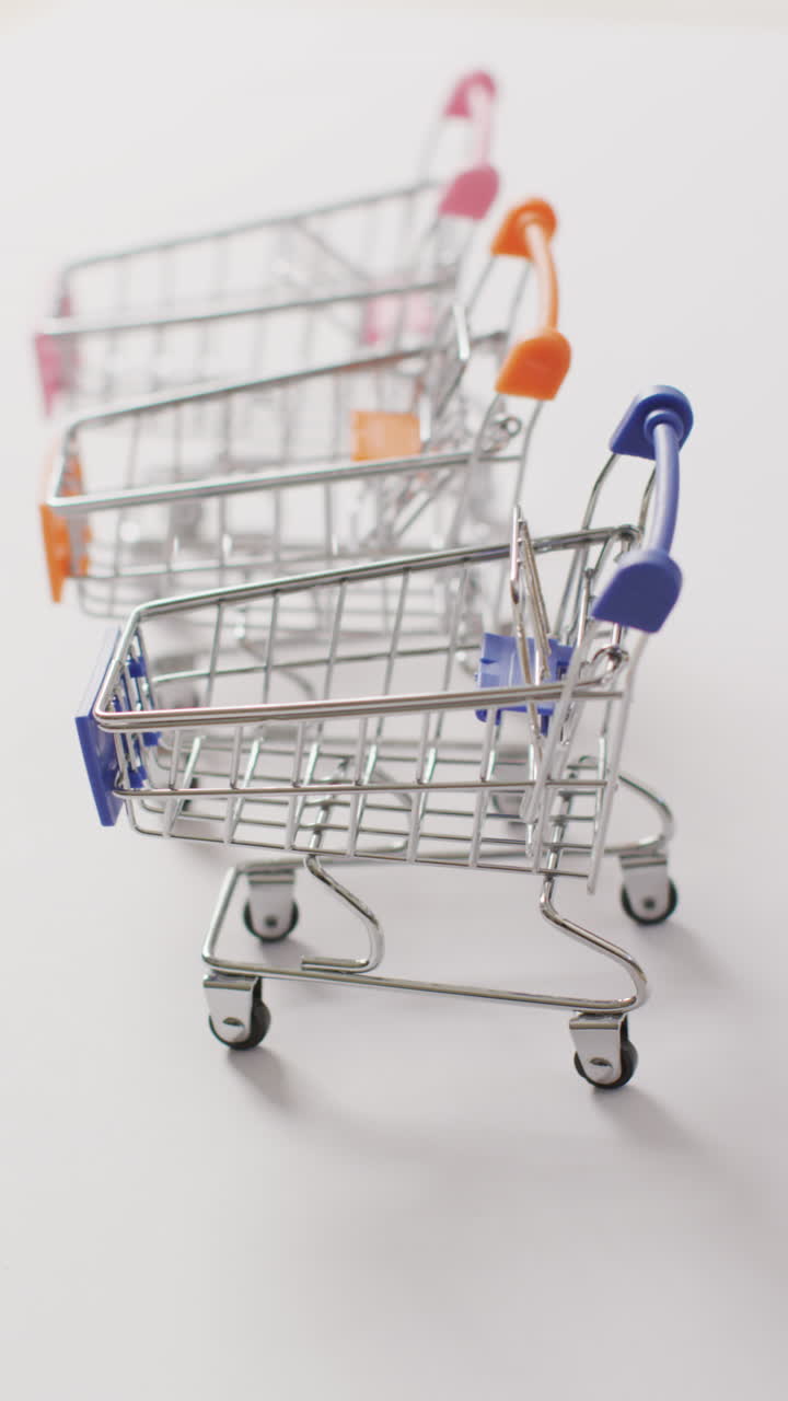 video vertical de tres carros de compras sobre un fondo blanco