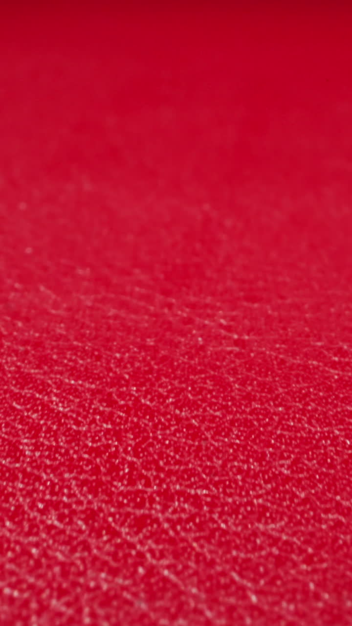 Crimson color cow leather material as background upper macro view. Sewing supplies for items crafting. Design ideas and decorative techniques