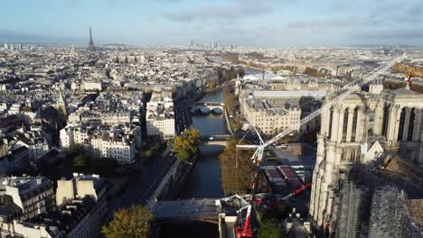 drone passes next to notre dame church, showing river seine and eiffel tower in the background