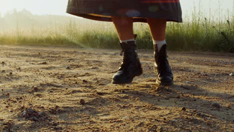 mujer caminando por un camino de campo al amanecer