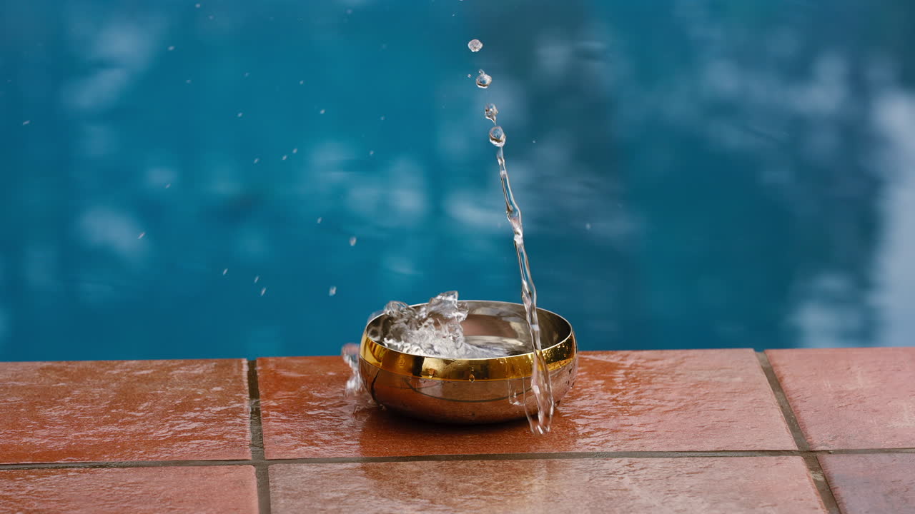 Dropping a small piece of metal in a bowel containing water at the edge ...