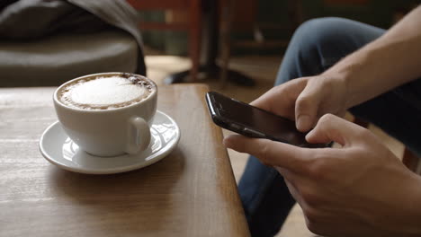 Junger-Mann-Im-Café,-Der-Nachrichten-Mit-Dem-Smartphone-Sendet,-Nahaufnahme