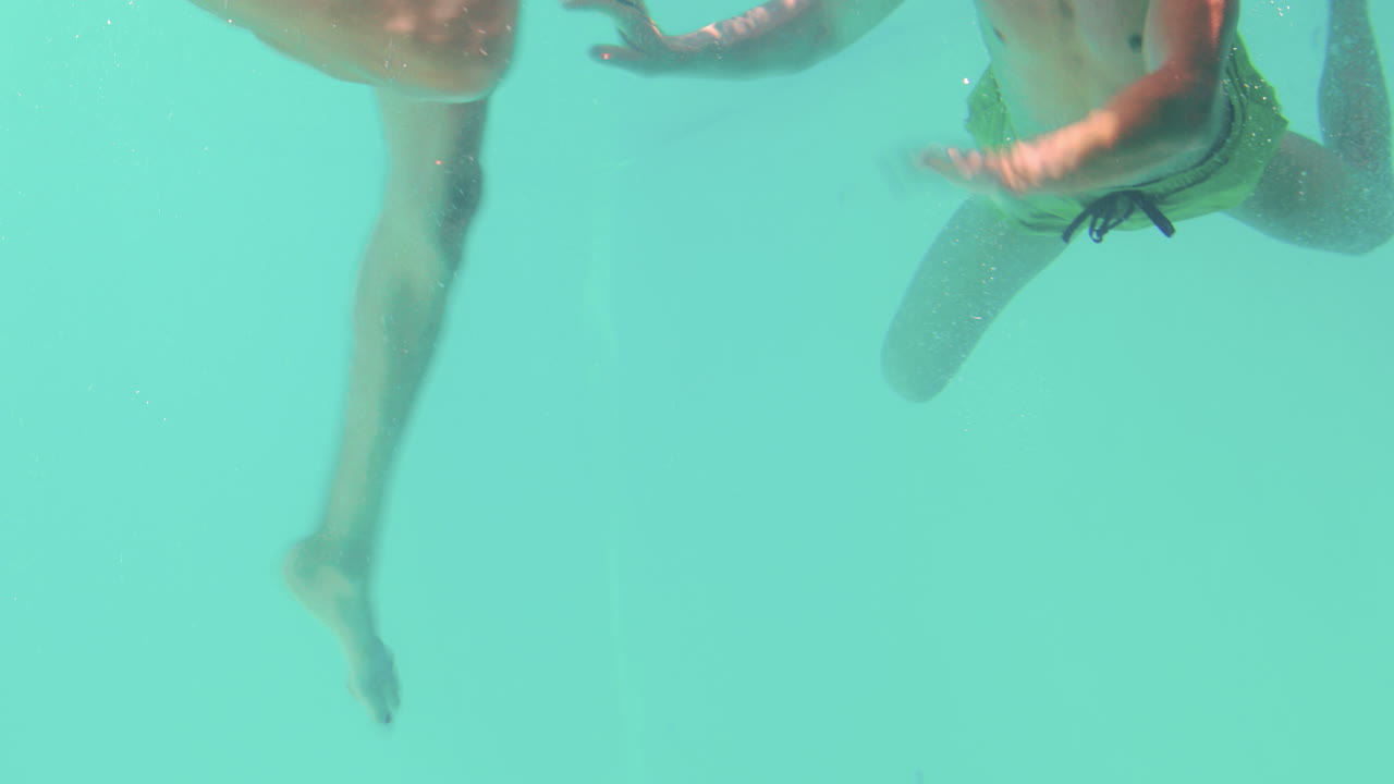 행복 한 커플 이 물  ⁇  에서 수영 하고 있다