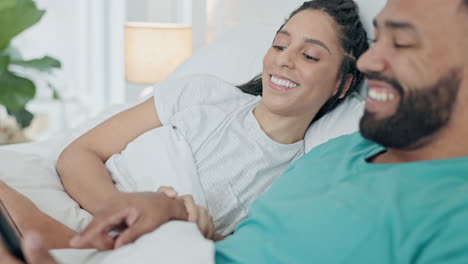 pareja feliz, hablando y relajándose con la tableta en la cama