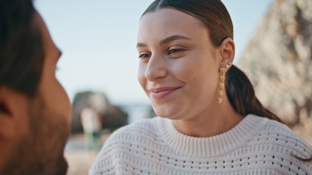 Closeup woman admiring husband sitting on seashore. Couple enjoying romantic day