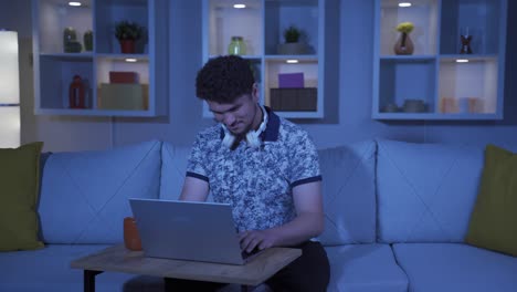 hombre feliz usando una computadora portátil por la noche.