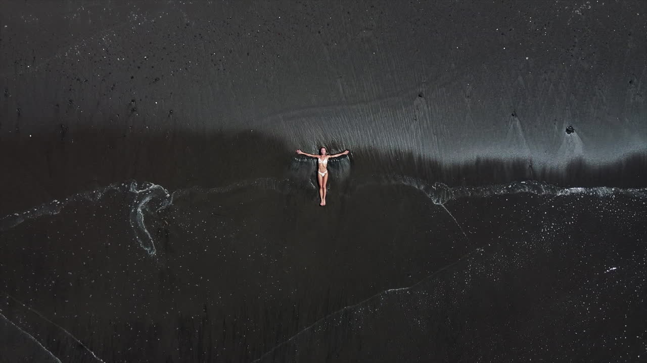 Woman Relaxing on Black Sand Beach