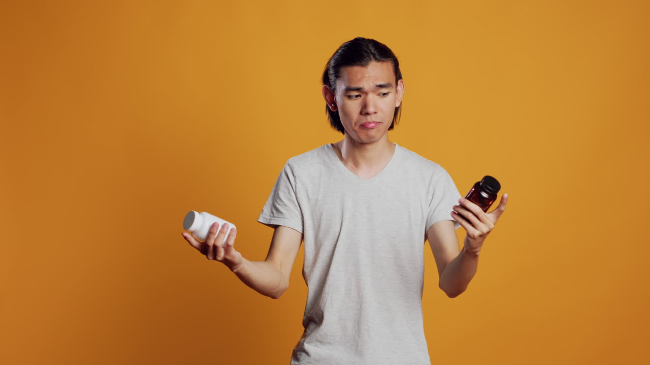 Young man being clueless about bottles of pills