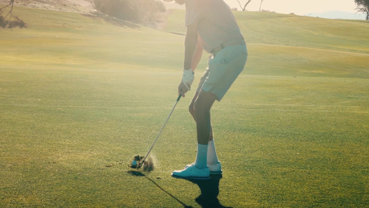 Golfer chunks wedge in extreme slow motion, tracking shot at golden hour at 4k 800fps of bad shot