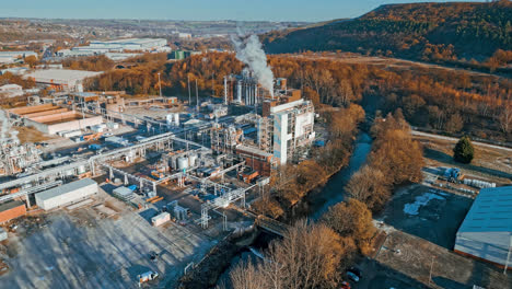 imágenes aéreas que avanzan hacia una gran planta química industrial, que muestran tuberías, estructuras metálicas, torres de refrigeración y almacenamiento de productos químicos