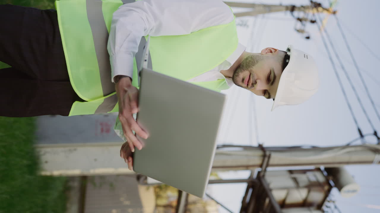 Engineer Inspecting Electrical Infrastructure with Laptop