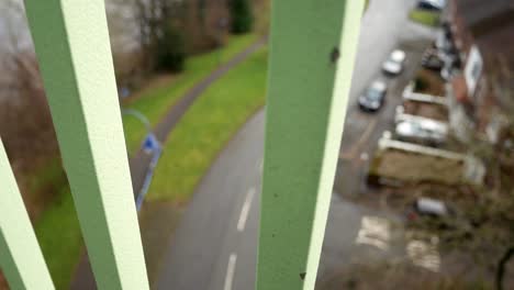 Blick-Durch-Metallbrücke-Fußgängerbrückengeländer-Auf-Die-Straße-Darunter-Traurigkeit-Gefühl-Langsam-Rechts-Dolly