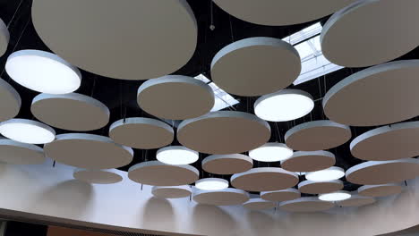 contemporary ceiling with circles. bright circular lights hang from a modern ceiling, creating a unique ambiance in a contemporary space