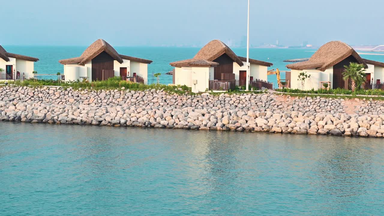 아랍 에미리트 에 있는 라스 알 카이마 의 해안선 에 있는 물 위 의 빌라 와 오두막