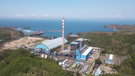 aerial view of the steam power plant located in pacitan district, between the hills and the southern coast of java island