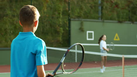 Rückansicht-Eines-Teenagers,-Der-Im-Sommer-Mit-Vater-Und-Kleiner-Schwester-Auf-Einem-Außenplatz-Tennis-Spielt-1