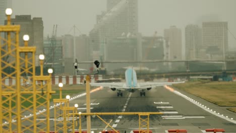 Un-Avión-Embrear-De-190-Pasajeros-Despegando-En-Un-Campo-Muy-Corto-En-El-Aeropuerto-De-La-Ciudad-De-Londres-Visto-Desde-Atrás-Con-Una-Lente-De-500-Mm.