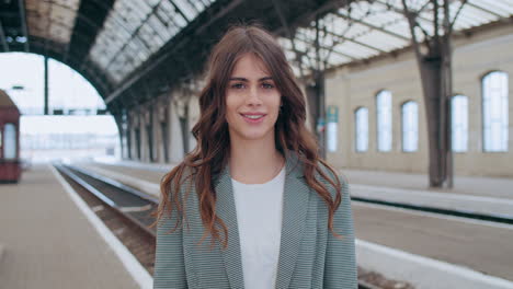 young woman smiling at a train station platform