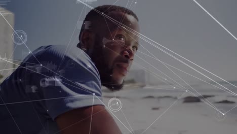 Network-of-connections-and-data-processing-over-african-american-man-enjoying-the-view-at-the-beach