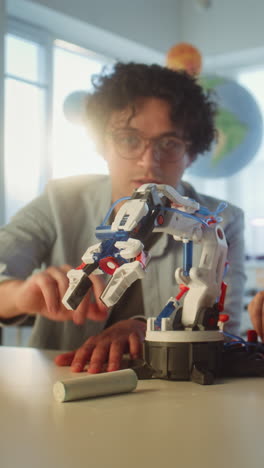 student interacting with a robot arm in a classroom