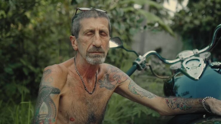 Uomo con tatuaggi e moto
