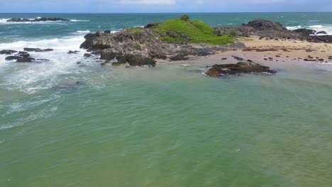 fly away at rocky headland towards seascape of sawtell beach near bonville in new south wales, australia