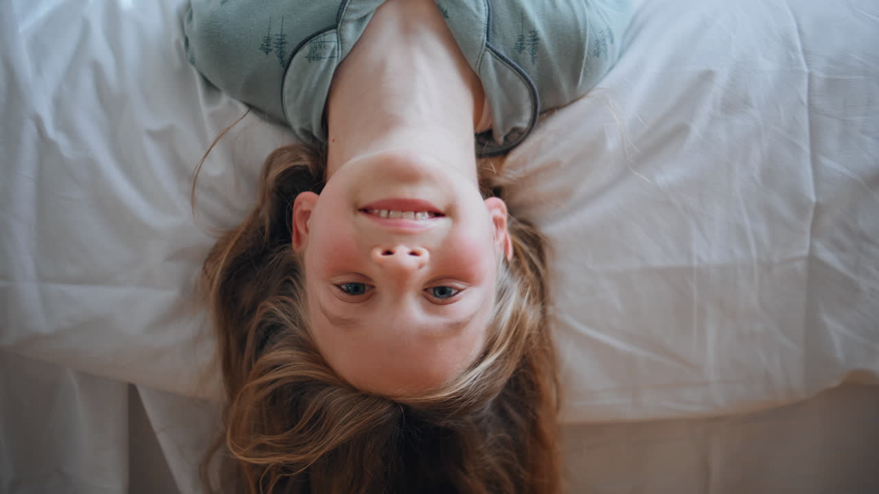 Funny baby lying bed portrait. Cute smiling little kid looking camera posing