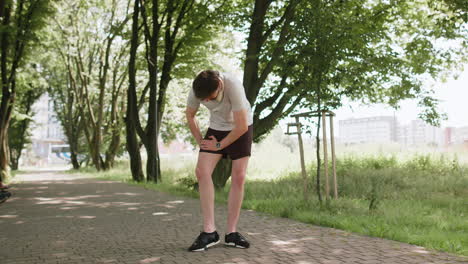 young runner man athlete with muscle pain massaging stretching trauma injury while jogging in park