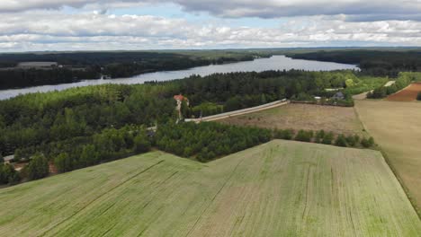 Vista-Aérea-Panorámica-De-Los-Campos-De-Cultivo-Y-Un-Lago-En-La-Zona-Rural-De-Borowy-Mill-En-Kashubia,-Pomorskie,-Polonia