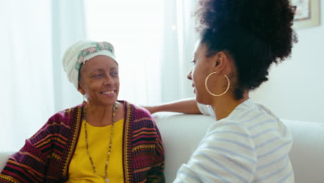senior african-american woman hugging young daughter at home