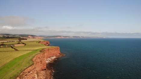 Aerial-Over-Farmland-Countryside-Landscape-Beside-English-Channel-In-Devon