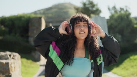 dance, headphones and a woman walking in a park