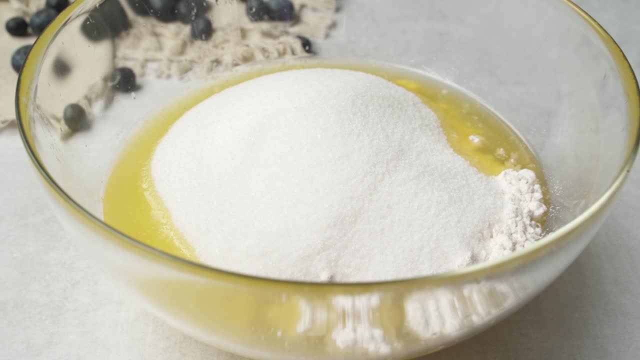 primer plano de azúcar para cocinar vertido en una mezcla para hornear de mantequilla y harina